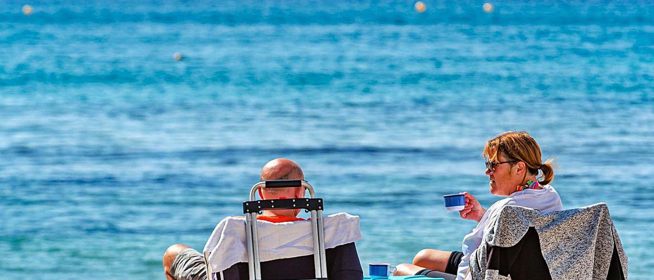 Un pareja de turistas disfrutando ayer de sol en la playa de Levante de Benidorm. | DAVID REVENGA