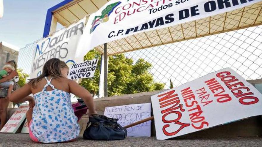 Un momento de la protesta ayer de los padres a las puertas del colegio público de Orihuela Costa con una niña jugando.