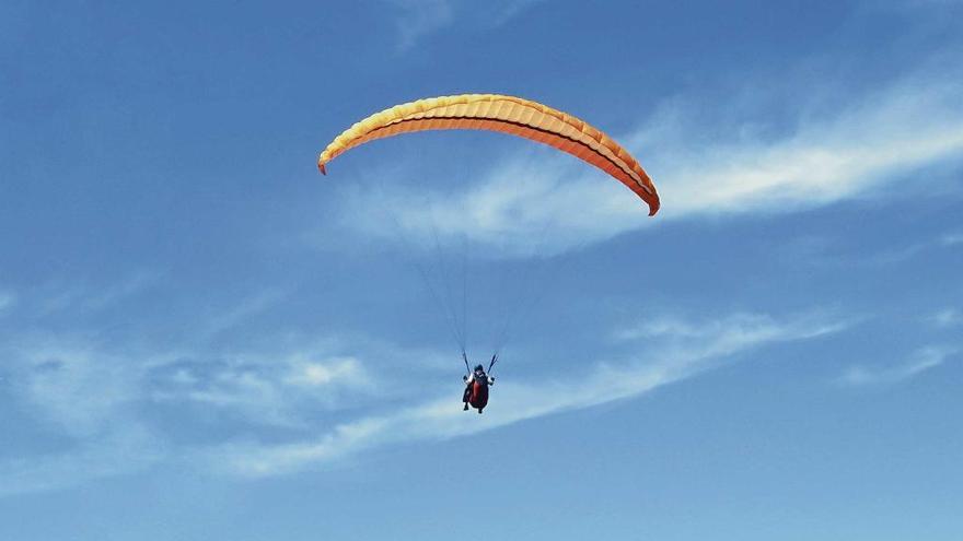 Un deportista vuela mientras practica parapente.