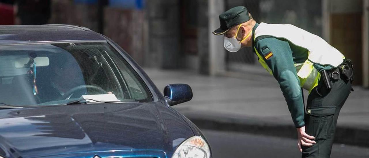 Un guardia con una mascarilla en un control en Grado.