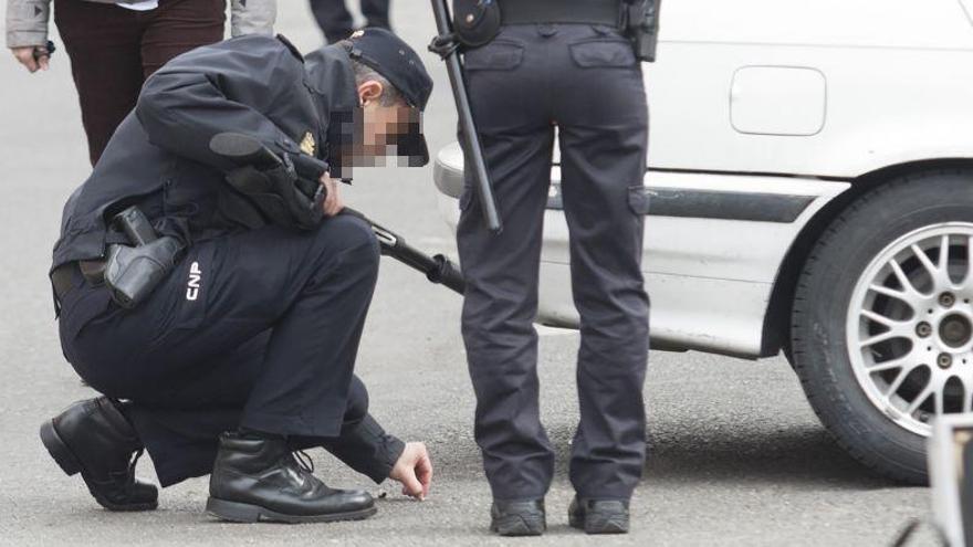 Un policía recoge un casquillo en el lugar del tiroteo