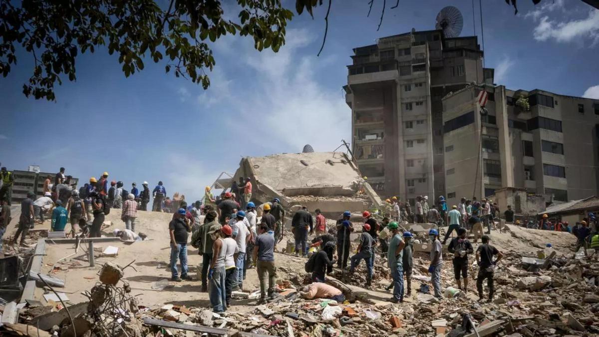 Rescatistas y voluntarios buscan víctimas en una vivienda afectada por los terremotos en Venezuela.
