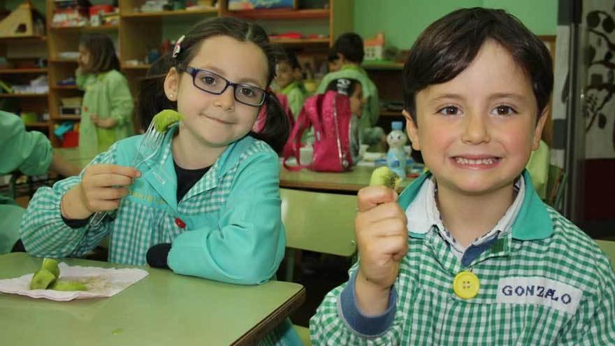 Dos alumnos del colegio San Félix comiendo un kiwi.