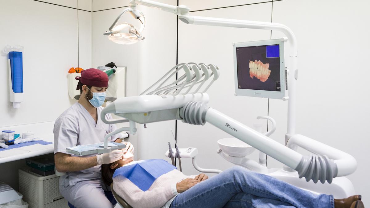Un dentista atendiendo a una paciente en su consulta
