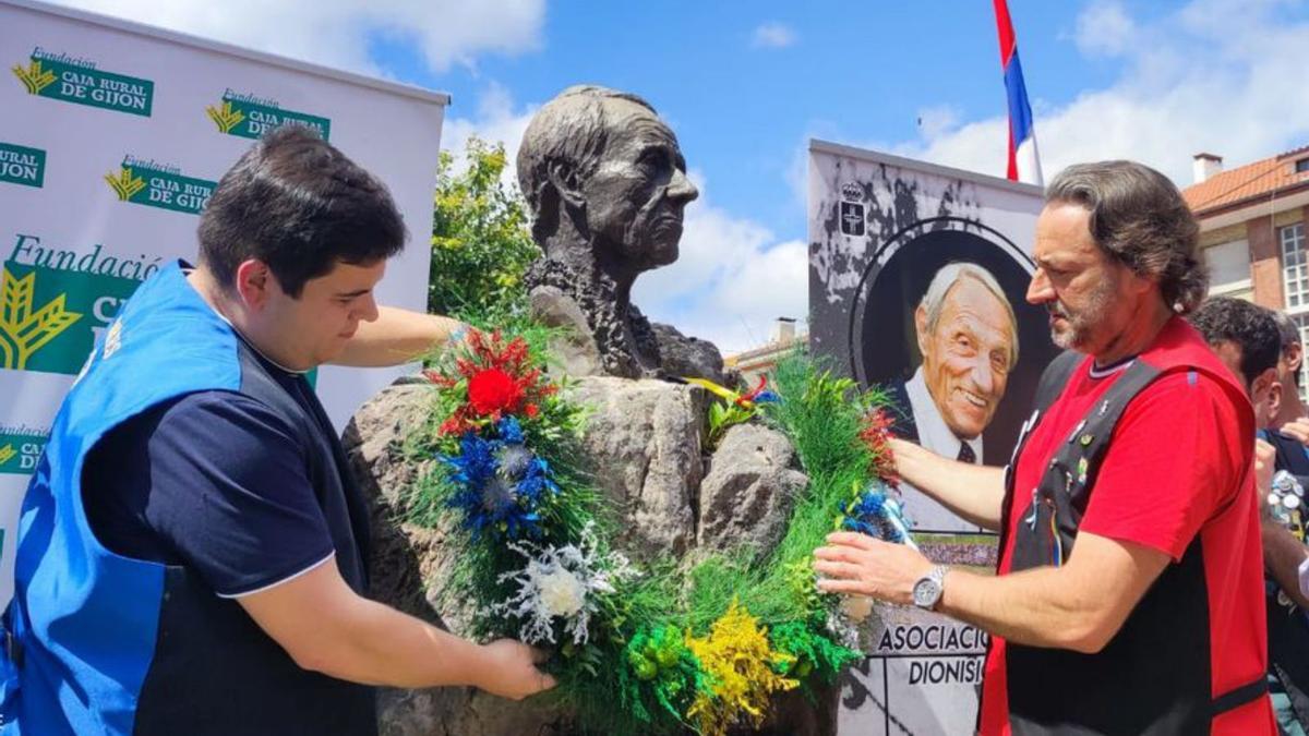 Víctor Caldevilla y Luis Fuentes colocan el collar de flores en el busto de Dionisio de la Huerta en Arriondas. | Juanjo Arrojo