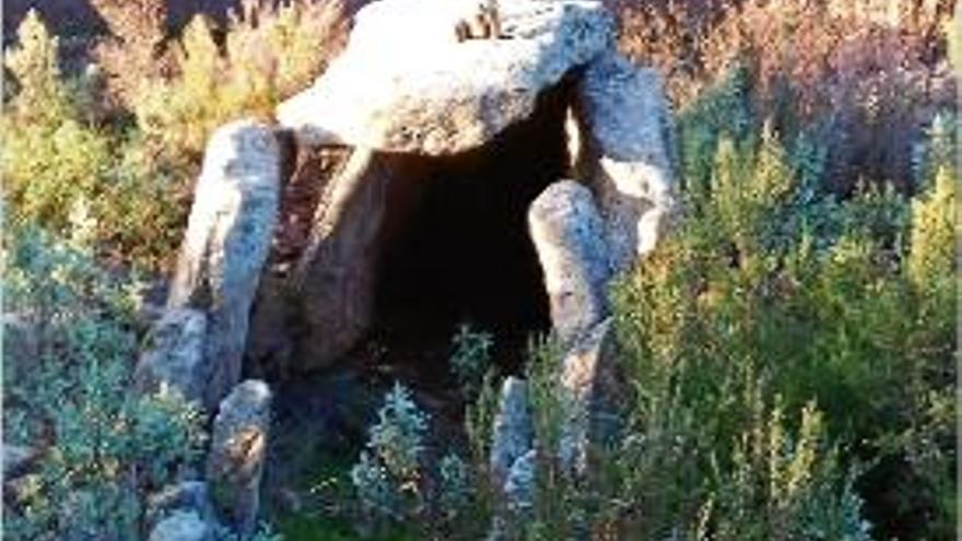 Imatge del dolmen amb la munició trobada i la zona cremada al fons.