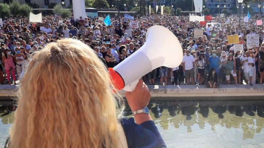 Una mujer habla a un grupo de negacionistas en una manifestación en Madrid.