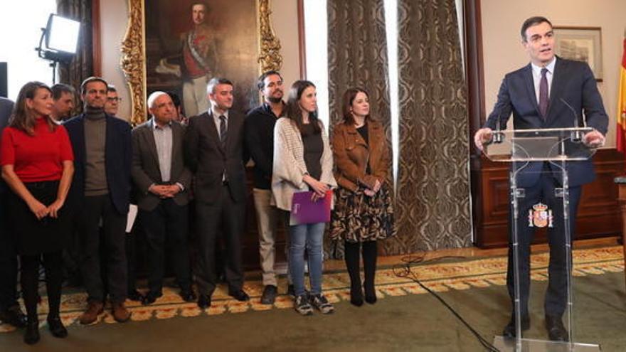 Yolanda Díaz, a la izquierda, durante la firma del pacto para gobernar en coalición entre Pedro Sánchez (PSOE) y Pablo Iglesias (Unidas Podemos).