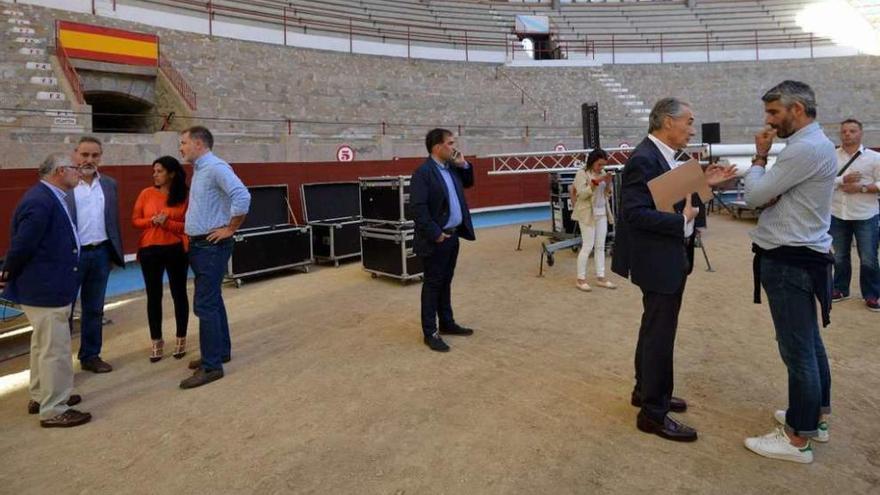 Responsables del PP supervisan la preparación de la plaza de toros para el mitin de hoy. // G.S.