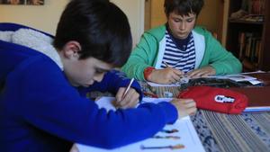 Dos estudiantes de quinto de primaria realizan sus deberes en casa de uno de ellos.