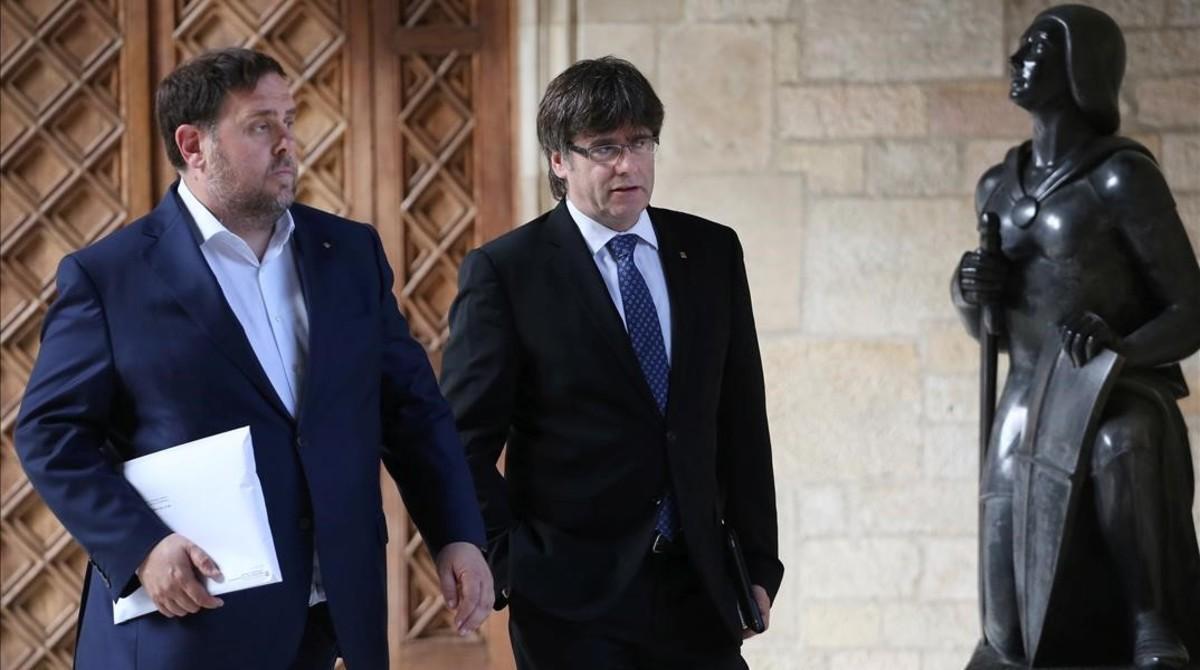 Oriol Junqueras y Carles Puigdemont se dirigen a la reunión del Consell Executiu, este martes.