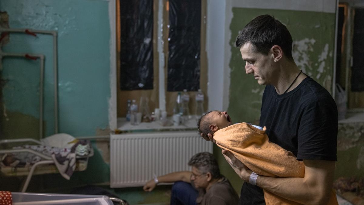 Un hombre sostiene a su bebé en un hospital que fue convertido en refugio anti aéreo, en Kiev.