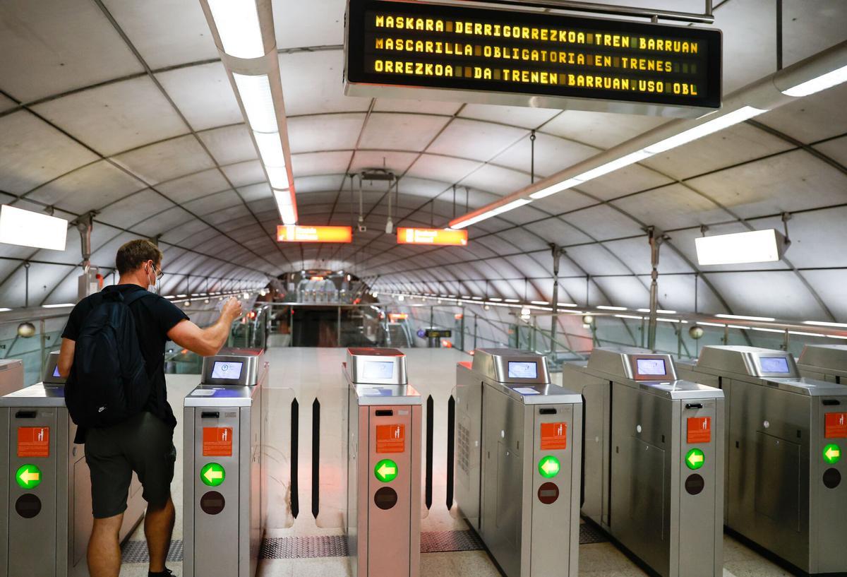 Un usuario del metro de Bilbao, entra por una maquina canceladora.