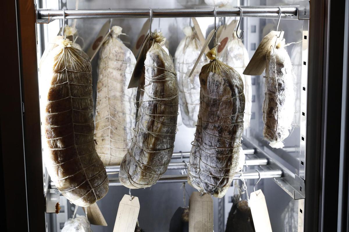 Imagen de unos embutidos de cerdo en pleno proceso de curación.