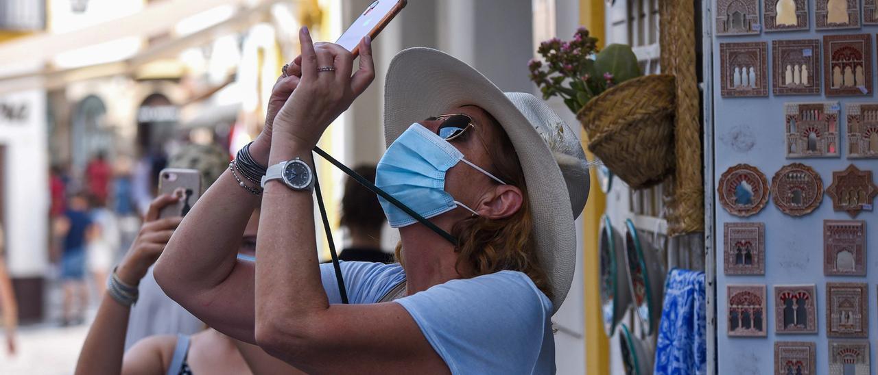 Dos turistas realizan fotografías en una calle de la Judería.