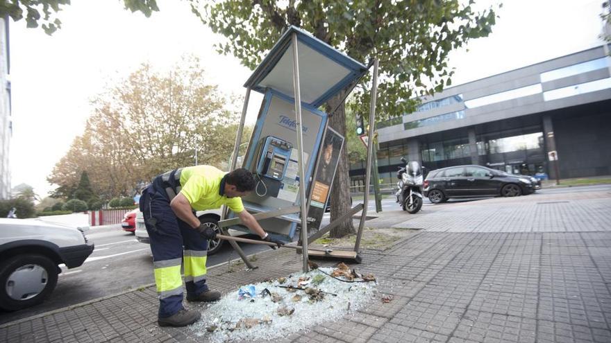 Un operario retira cristales de la cabina destrozada.