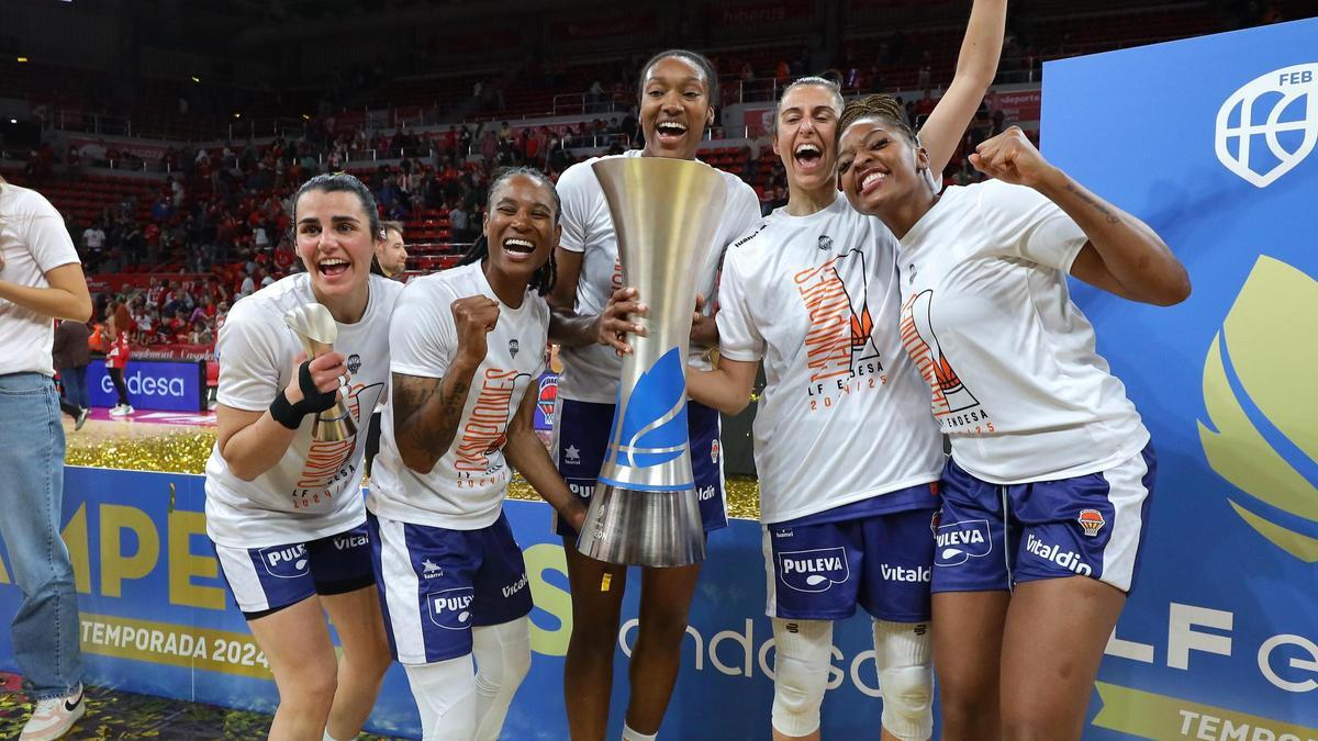 Parte del conjunto taronja con la copa de campeonas