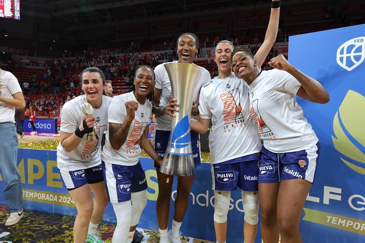 Parte del conjunto taronja con la copa de campeonas