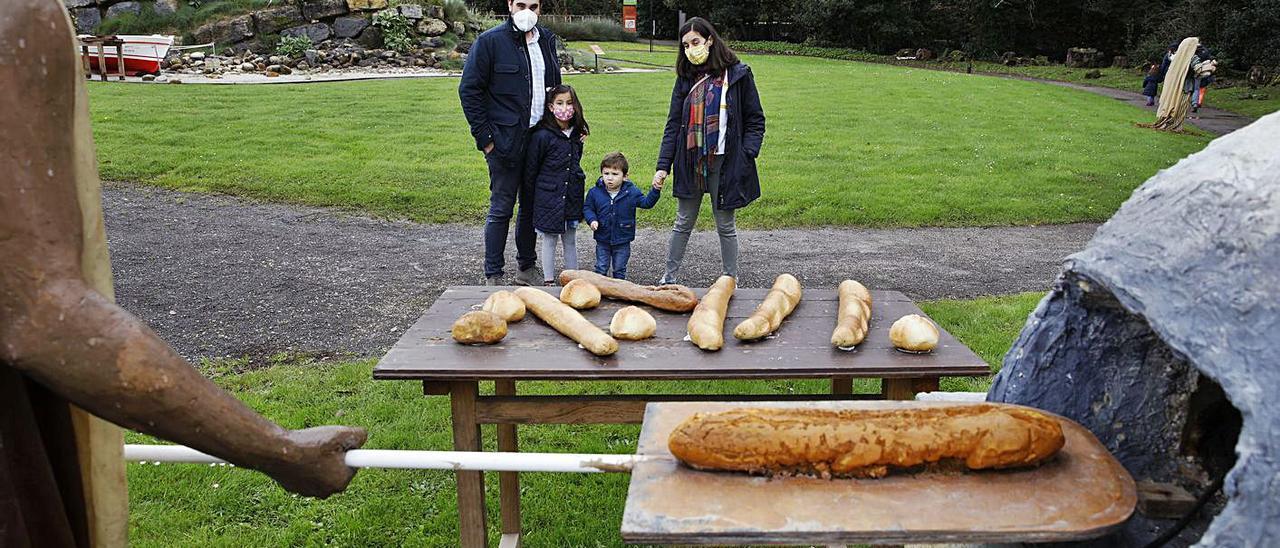 Una familia, ante una de las piezas del belén que acoge el Jardín Botánico Atlántico. | Ángel González