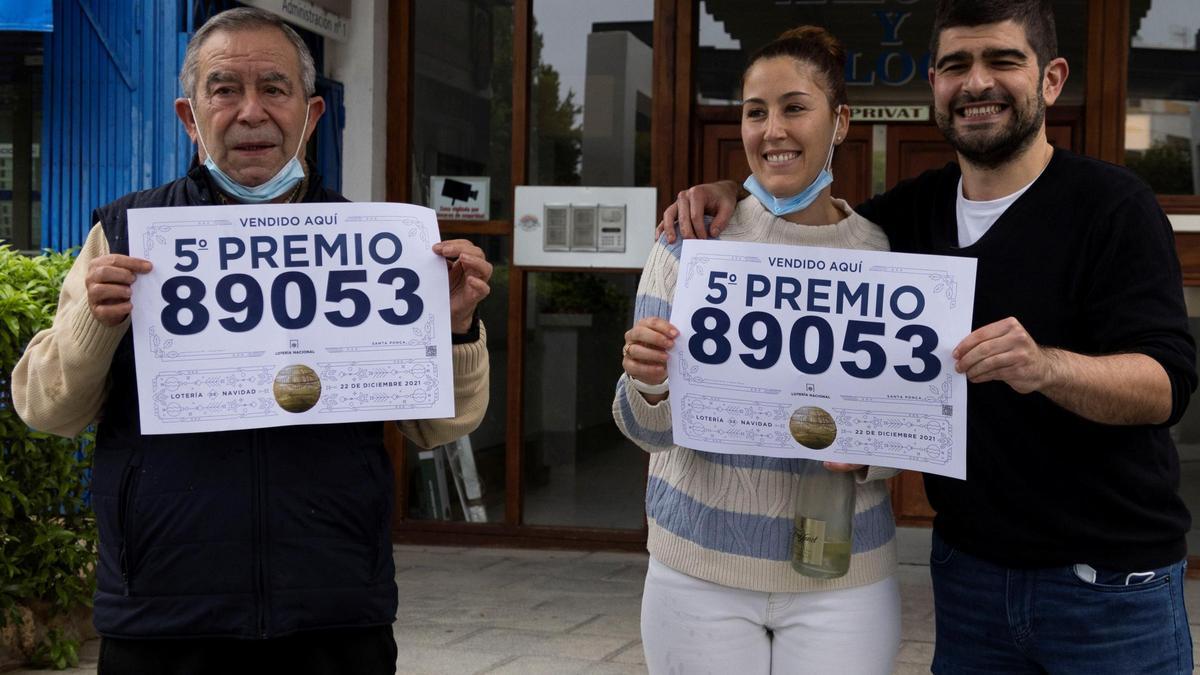 Los premiados sujetan dos boletos de los premios