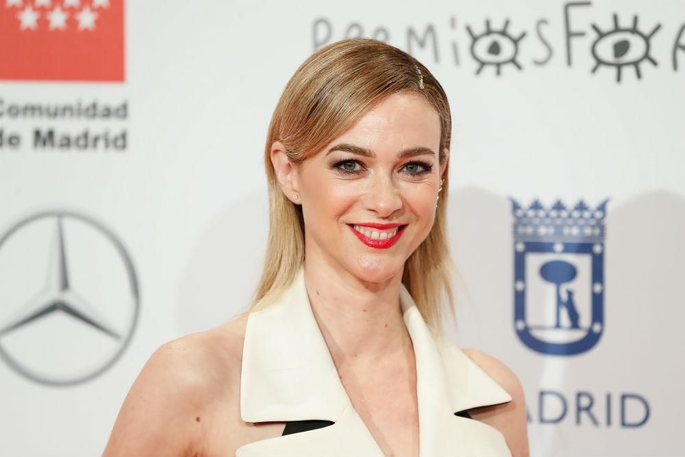 Marta Hazas posa sonriente en la alfombra roja de los Premios Forqué con un peinado con su melena suelta peinada con raya a un lado por detrás de las orejas