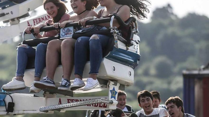 Varios jóvenes en una de las atracciones de las fiestas de San Antonio de La Florida.