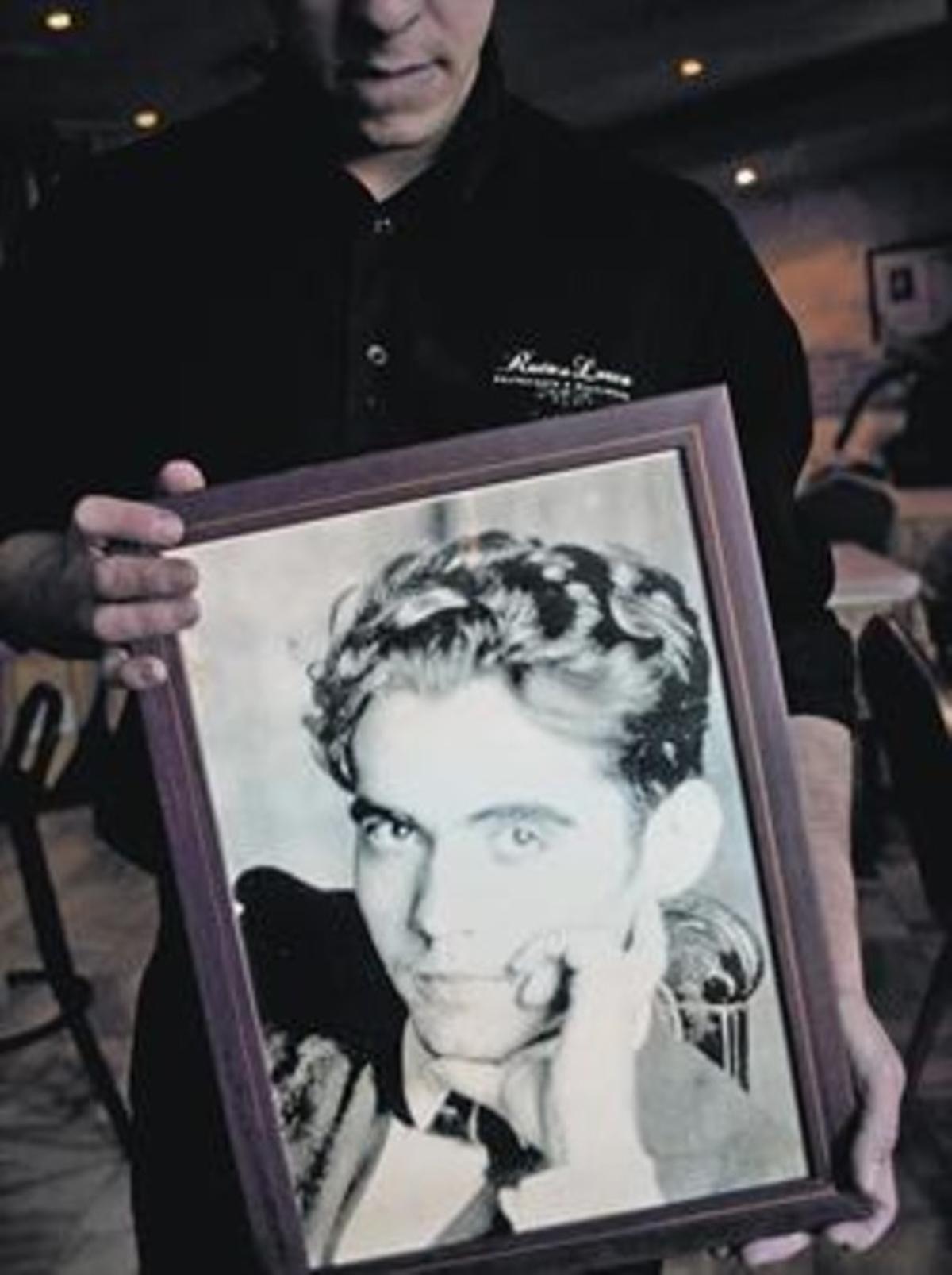 Un camarero muestra un retrato de Lorca en un restaurante en Alfacar (Granada), cerca de donde se cree que están los restos del poeta.