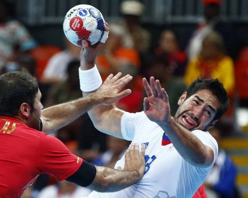Spain's Joan Canellas Reixach pushes France's Nikola Karabatic as he attempts to score in their men's handball quarterfinals match at the Basketball Arena in London