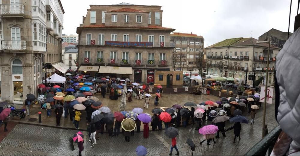 Los vigueses esperan bajo la lluvia el inicio de la representación.