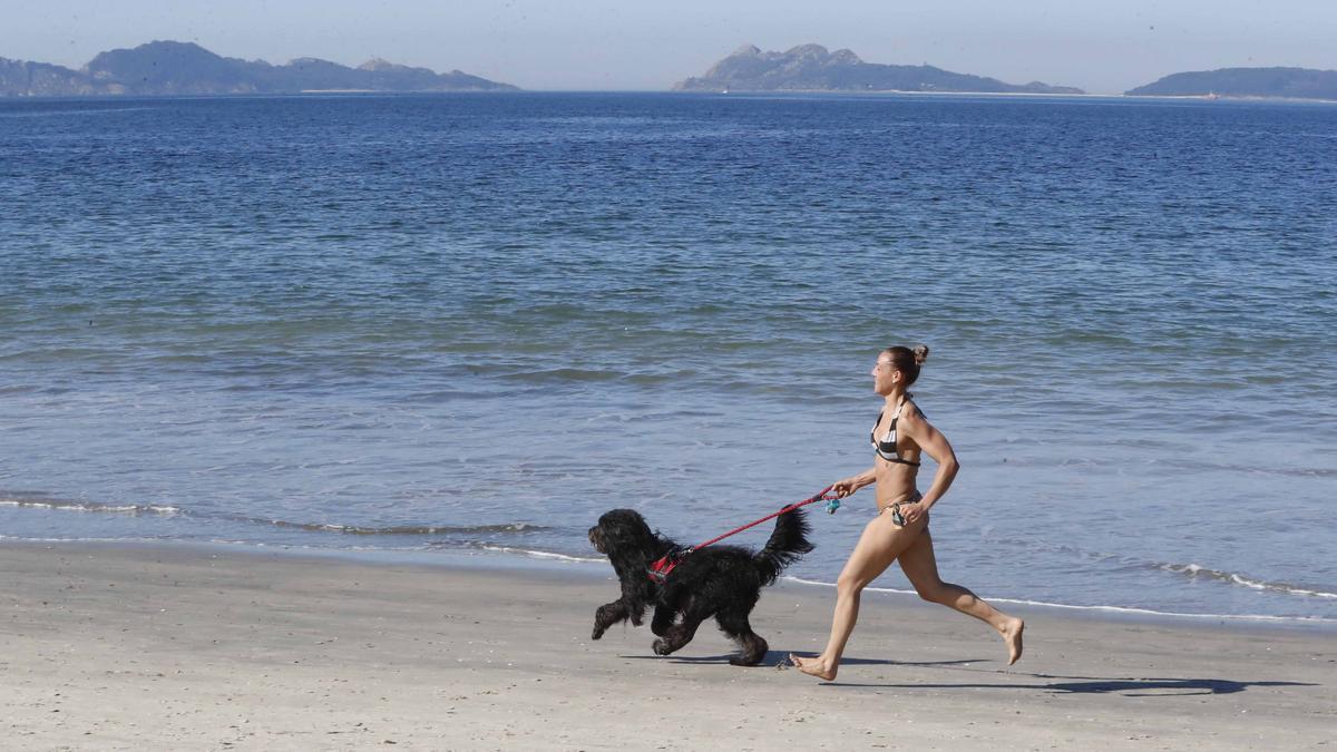 Una mujer corre con su perro por Samil, esta mañana