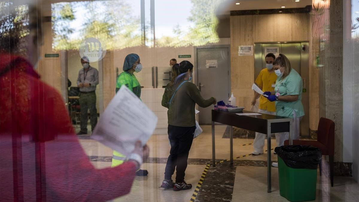 Una enfermera (derecha) recibe a una paciente con covid-19 en un hotel en Leganés para que pase la cuarentena, el 15 de octubre del 2020