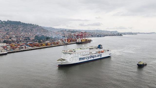 Arriba: Uno de los buques de la ONG. A la izquierda del texto, firma del acuerdo entre Mercy Ships y Navalia.  |  | NAVALIA