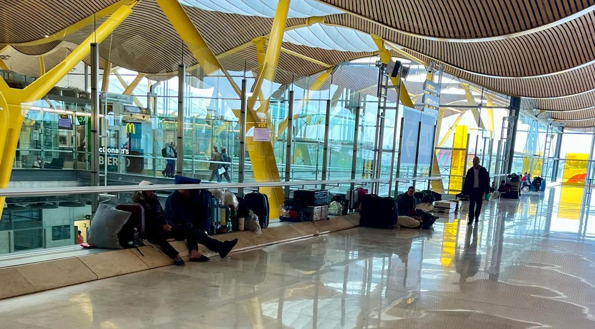 Una hilera de personas sin hogar que pernoctan en el aeropuerto Madrid Barajas