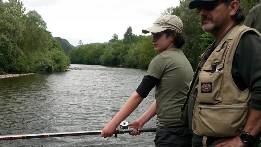Pedro García Peláez observa el río mientras su hijo Pedro pesca.