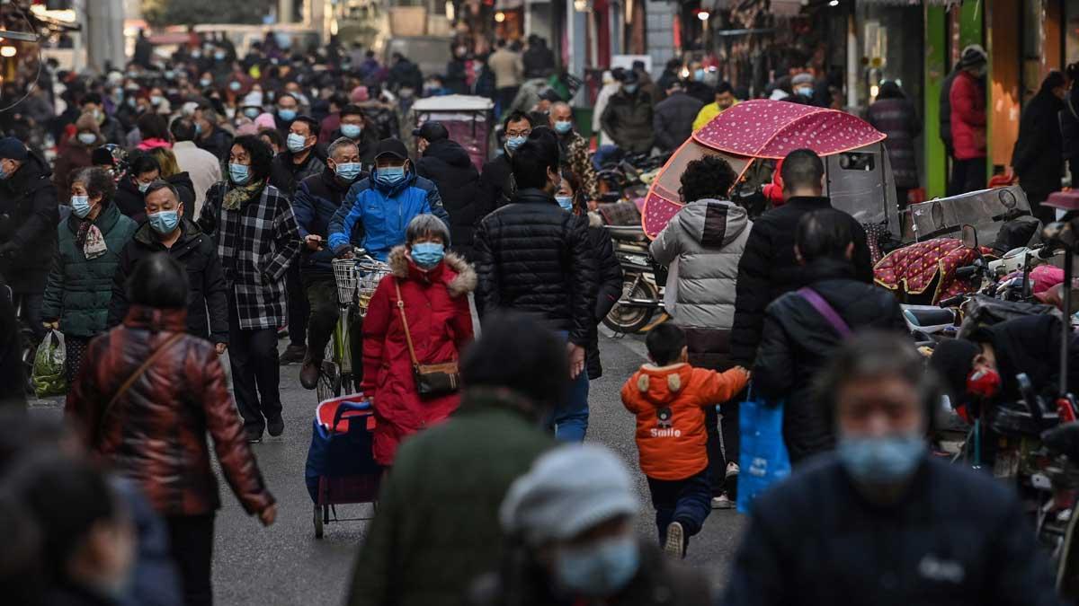 Gente por una céntrica calle, cerca del mercado de Wuhan