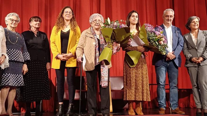 Generosa’l Llano y Gisele Fernandes de Almeida, con sendos ramos de flores, acompañadas de los representantes municipales y de varias premiadas en ediciones anteriores.