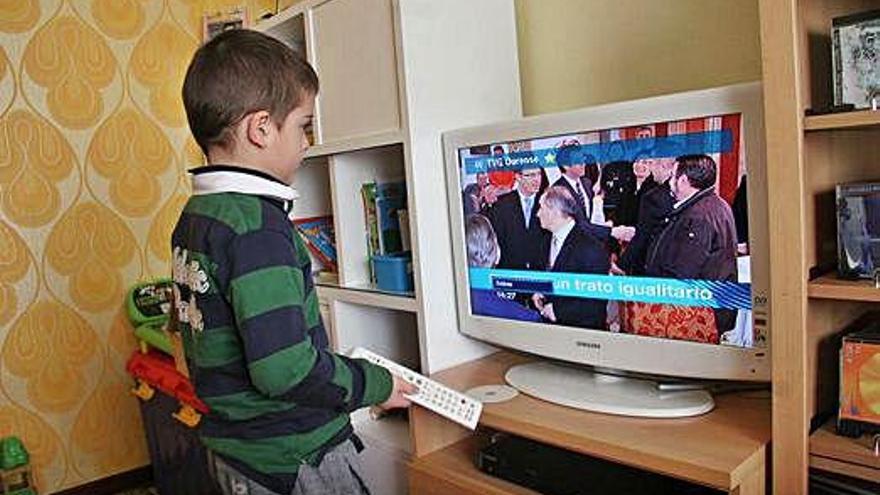 Un niño frente al televisor en su domicilio.