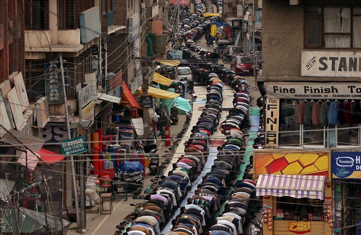 Numerosos musulmanes realizan oraciones en la calle, frente a una mezquita, el primer viernes del santo mes de ayuno de Ramadán, en Srinagar, Cachemira.