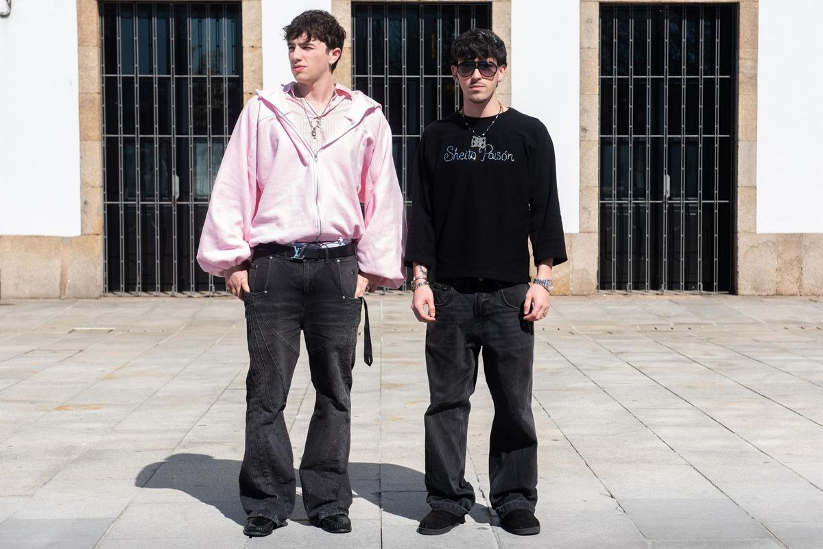Los dos diseñadores coruñeses, posando con algunas de sus prendas en la Marina.