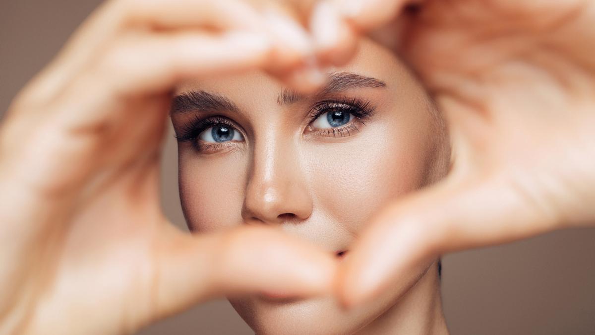 Chica haciendo corazón con la mano y enmarcando la mirada