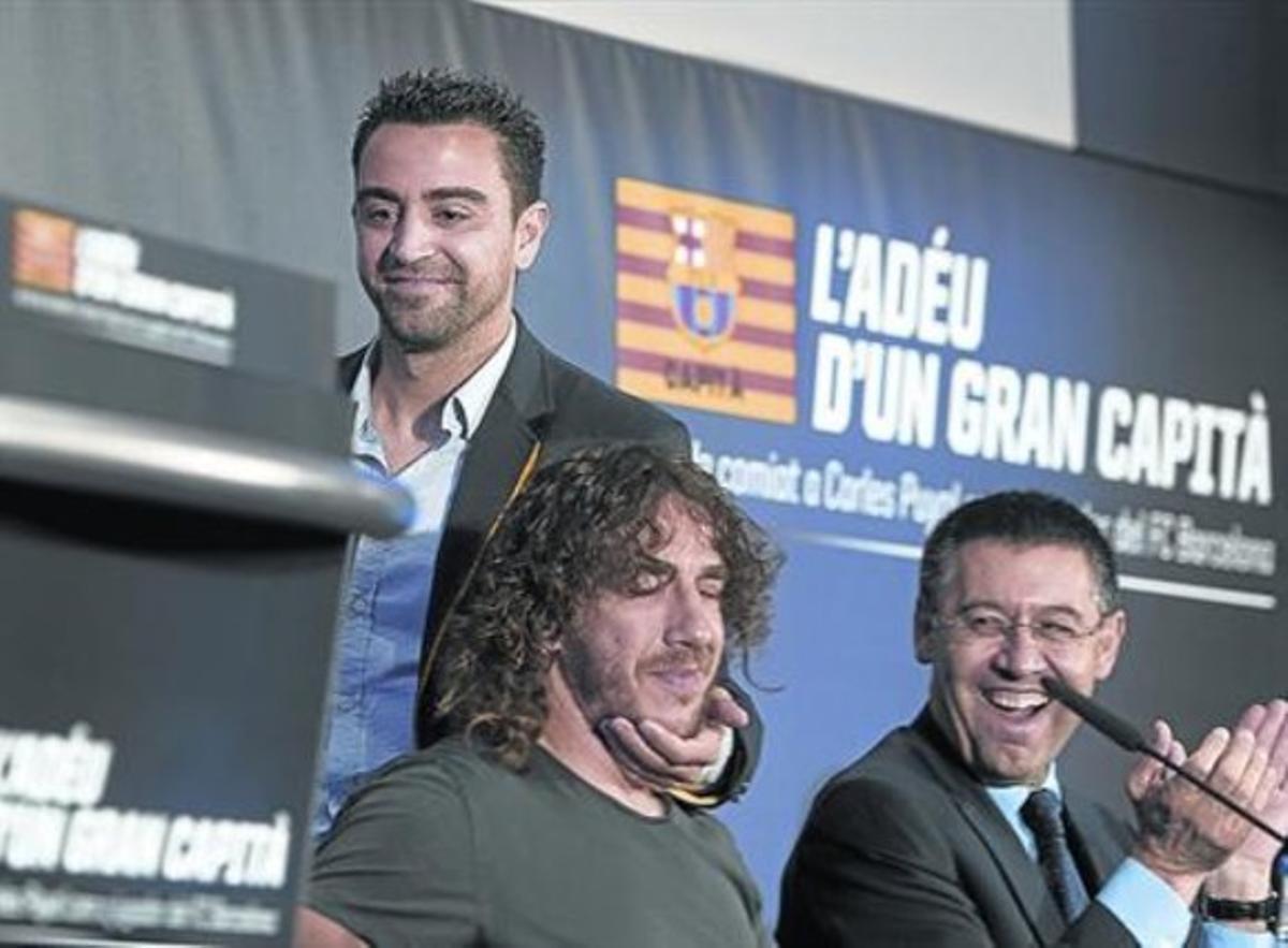 Xavi saluda Puyol, al costat de Bartomeu. A baix, el braçalet commemoratiude l’acte d’ahir. Xavi saluda Puyol, al costat de Bartomeu. A baix, el braçalet commemoratiude l’acte d’ahir.