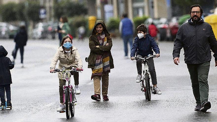 Peatones y niños en bici, pasean ayer por Areal, una de las calles cerradas al tráfico.  // Ricardo Grobas