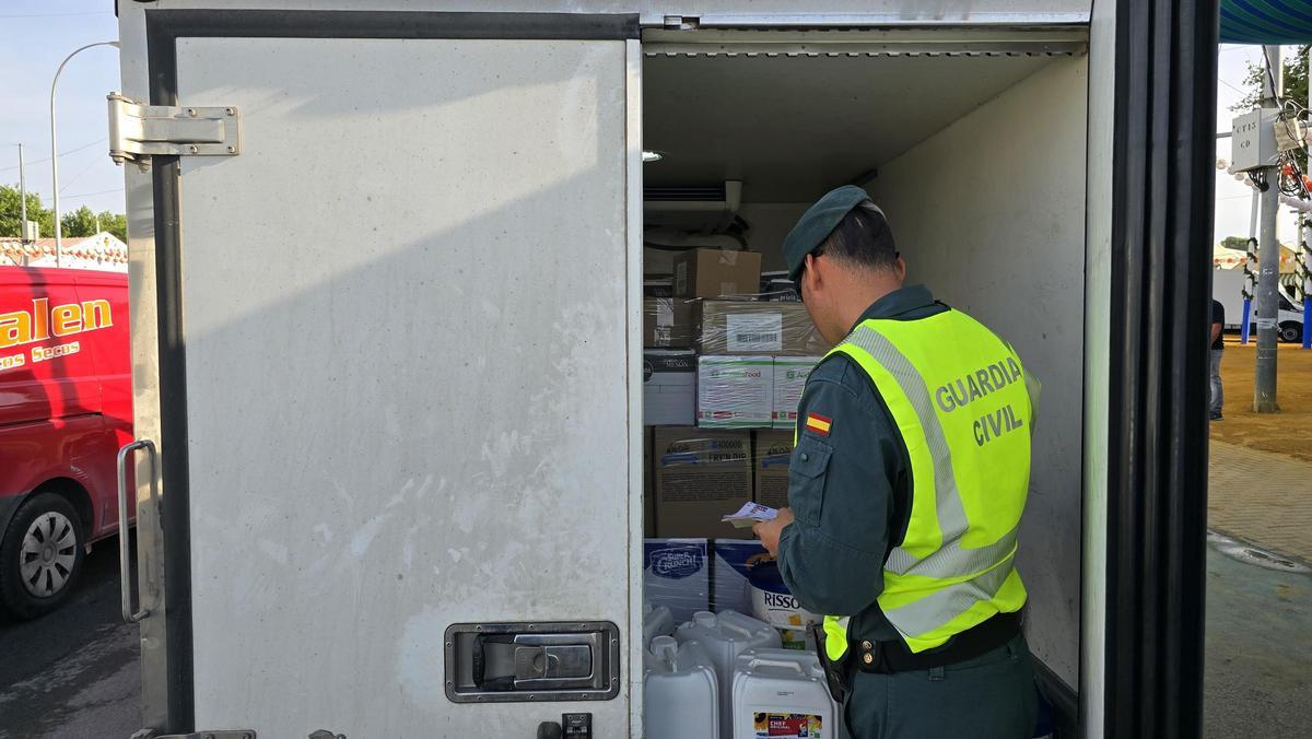 Un guardia civil revisa los alimentos de una furgoneta en el Real de la Feria de Sevilla.