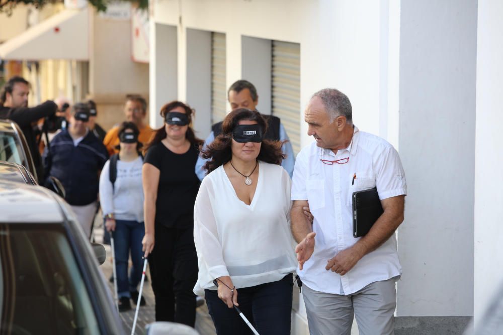 Algunas personas, entre ellos políticos, comprueban las dificultades de moverse por la calle que sufren las personas con discapacidad visual.