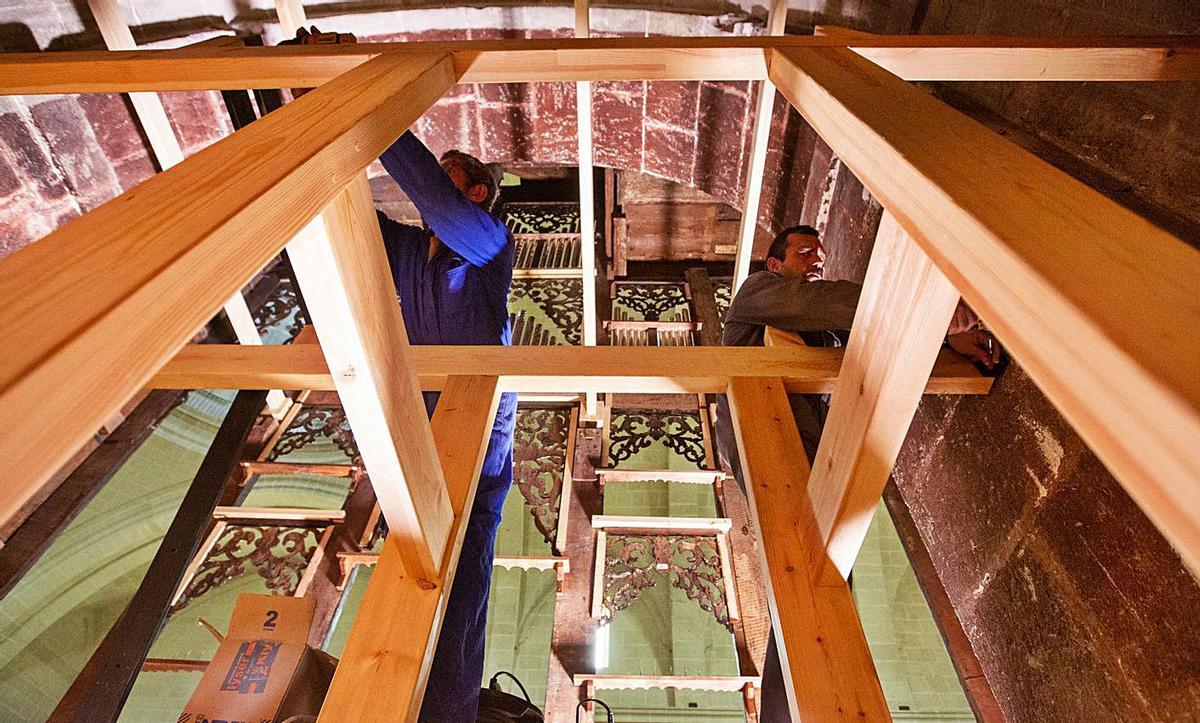 Dos operarios trabajan en el interior de la caja del órgano. | RAFA ARJONES