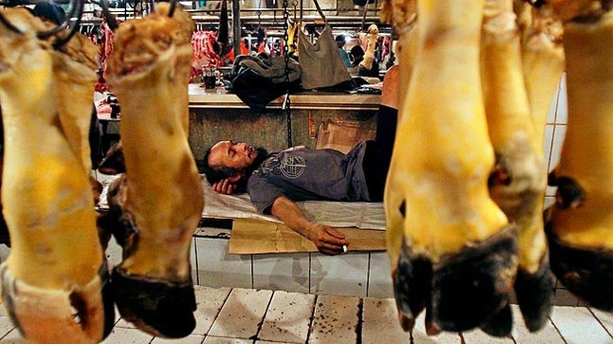 Un carnisser indonesi descansa al mercat de Jakarta.