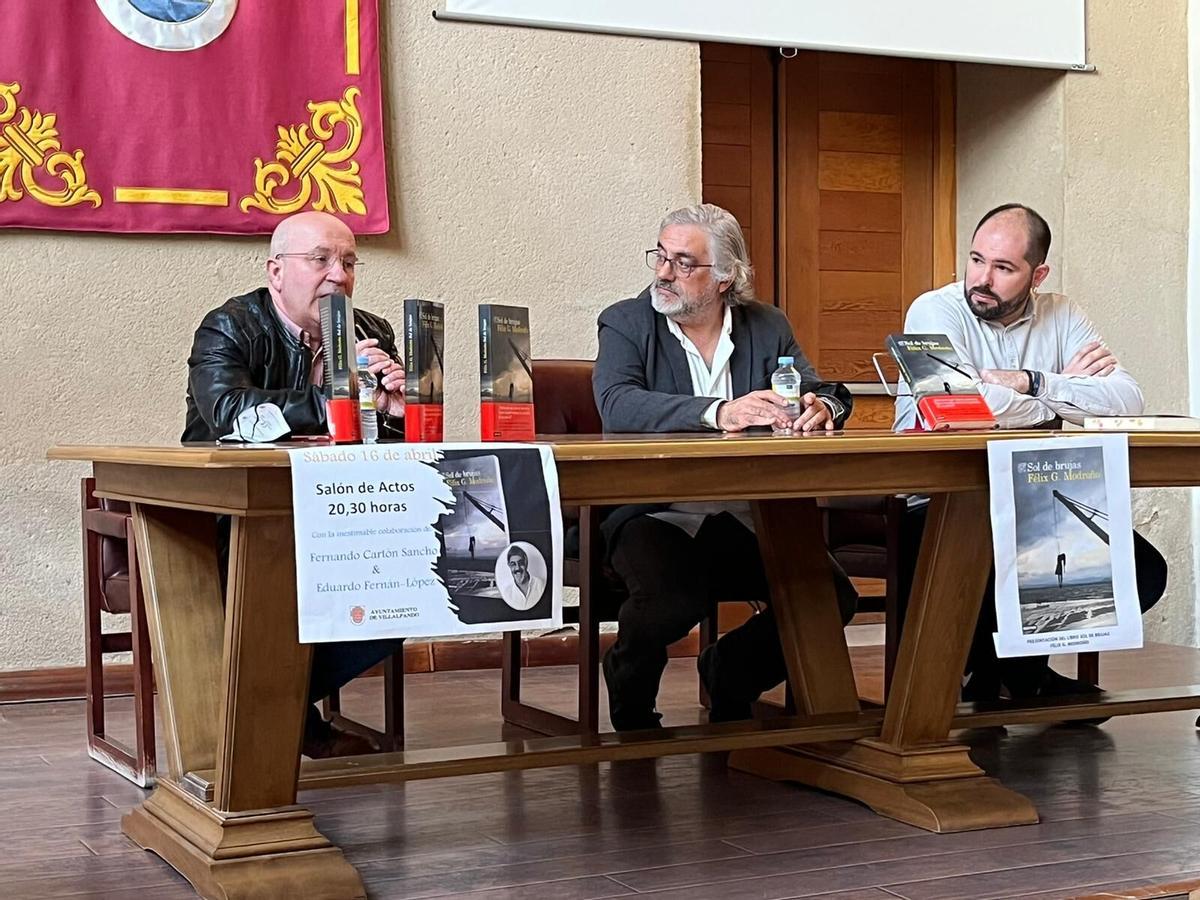 Arriba, Fernando Cartón Sánchez, Félix G. Modroño y Eduardo Fernán-López en la presentación de "Sol de brujas", novela de Modroño. Abajo, público asistente al acto. | Cedidas