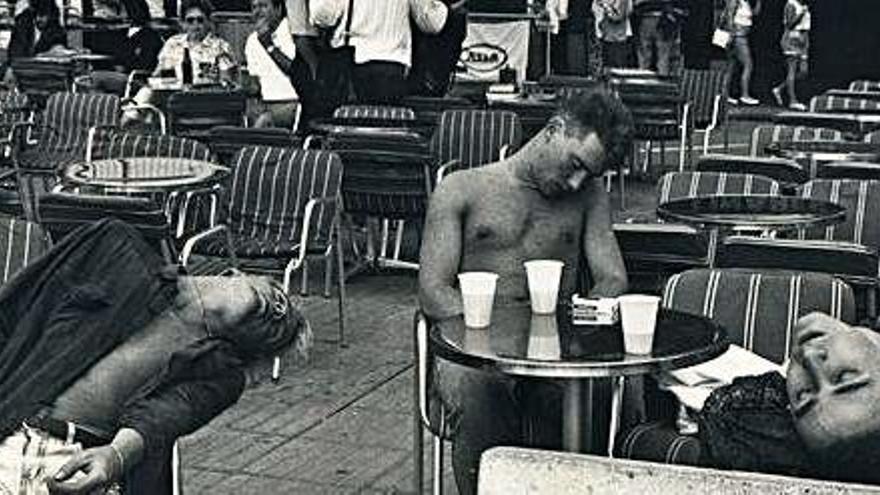 Tres jóvenes turistas durmiendo en la terraza de un bar, en una imagen de los años 90.