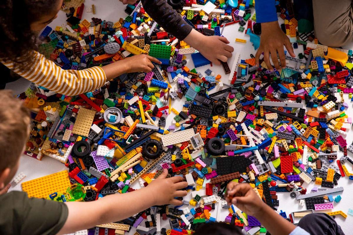Unos niños juegan con figuras de Lego. 