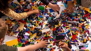 Unos niños juegan con figuras de Lego. 